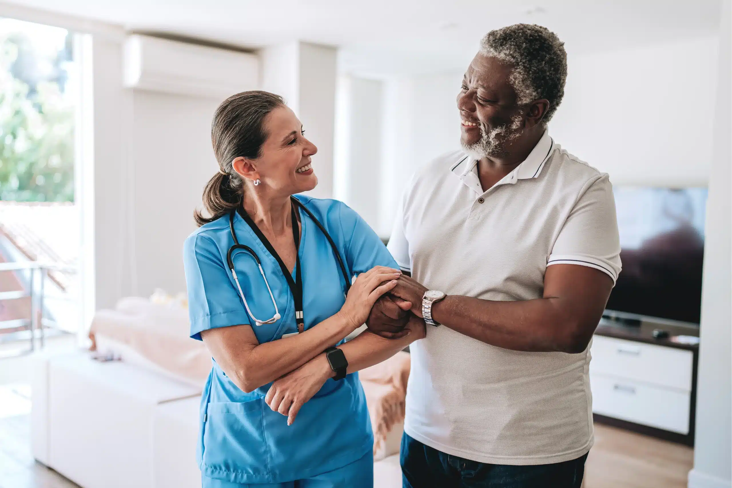 A nurse assists an older man in a cozy setting, providing care and support in a warm environment.